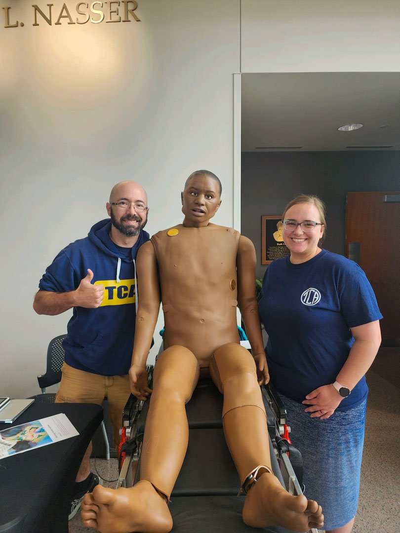 two tri-county EMS emt team members posing with a dummy